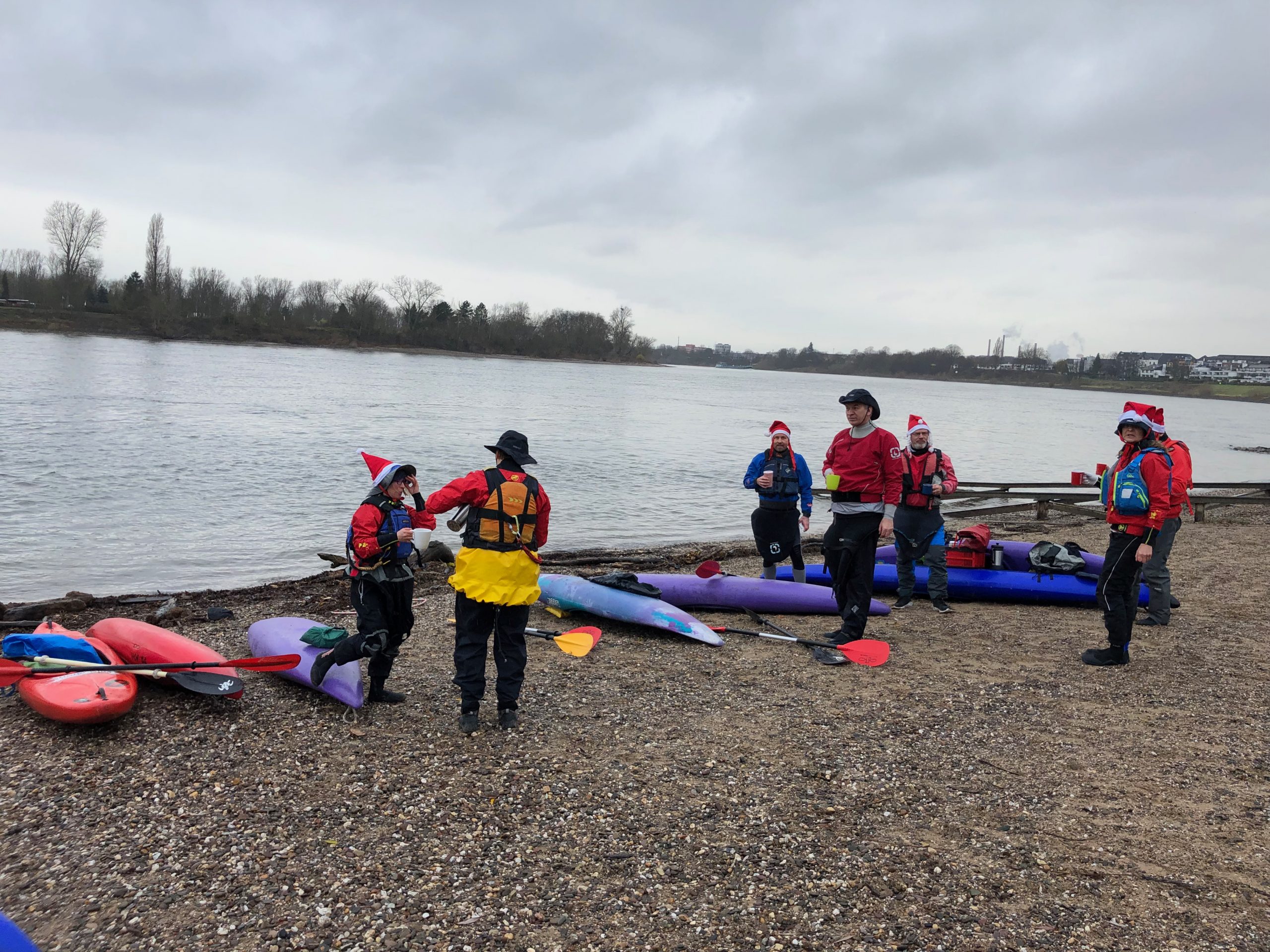 Mehrere Kanufahrer am Rheinufer
