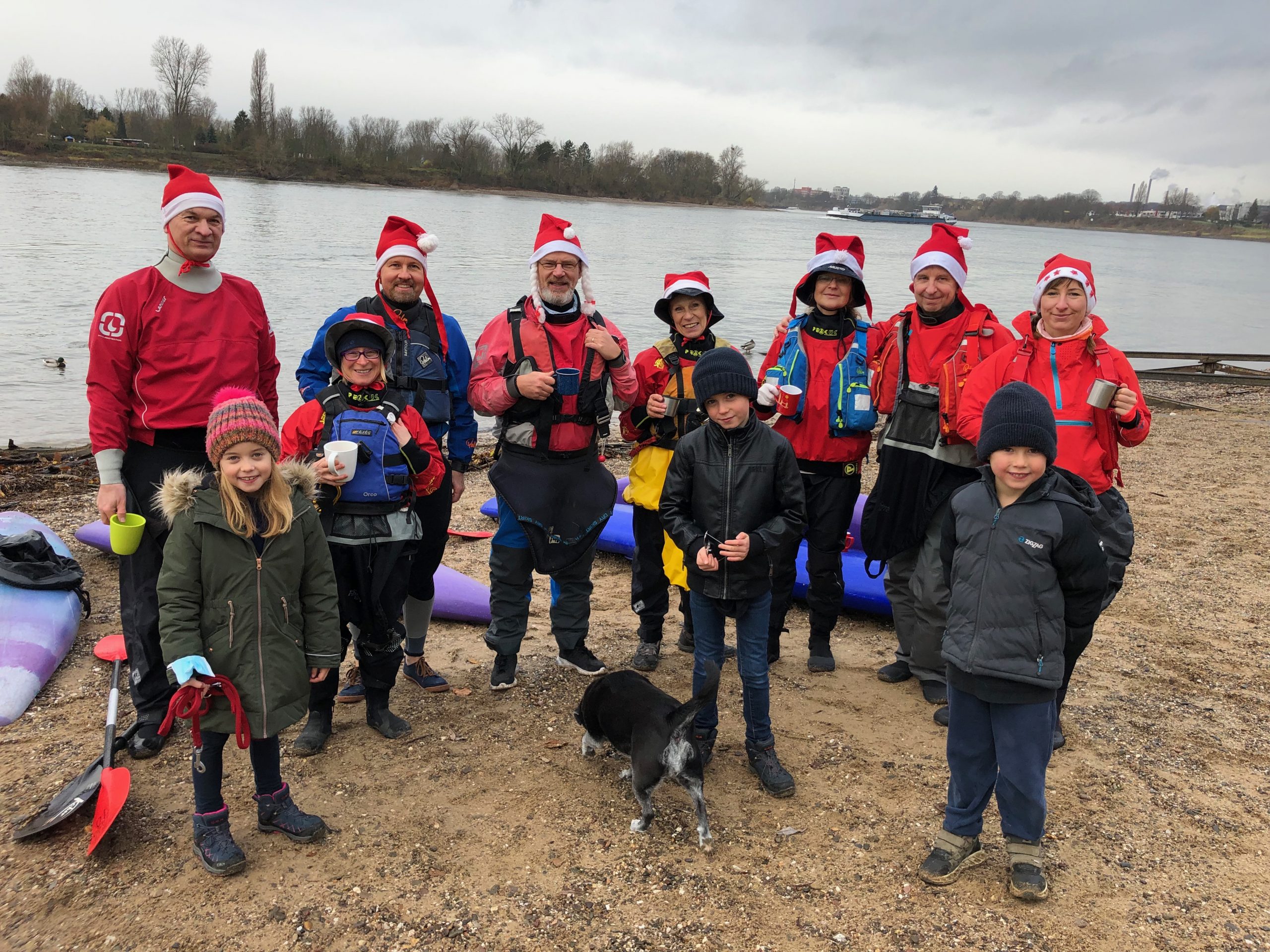 Gruppenbild Kanufahrer mit Nikolausmützen am Rheinufer mit Kinder