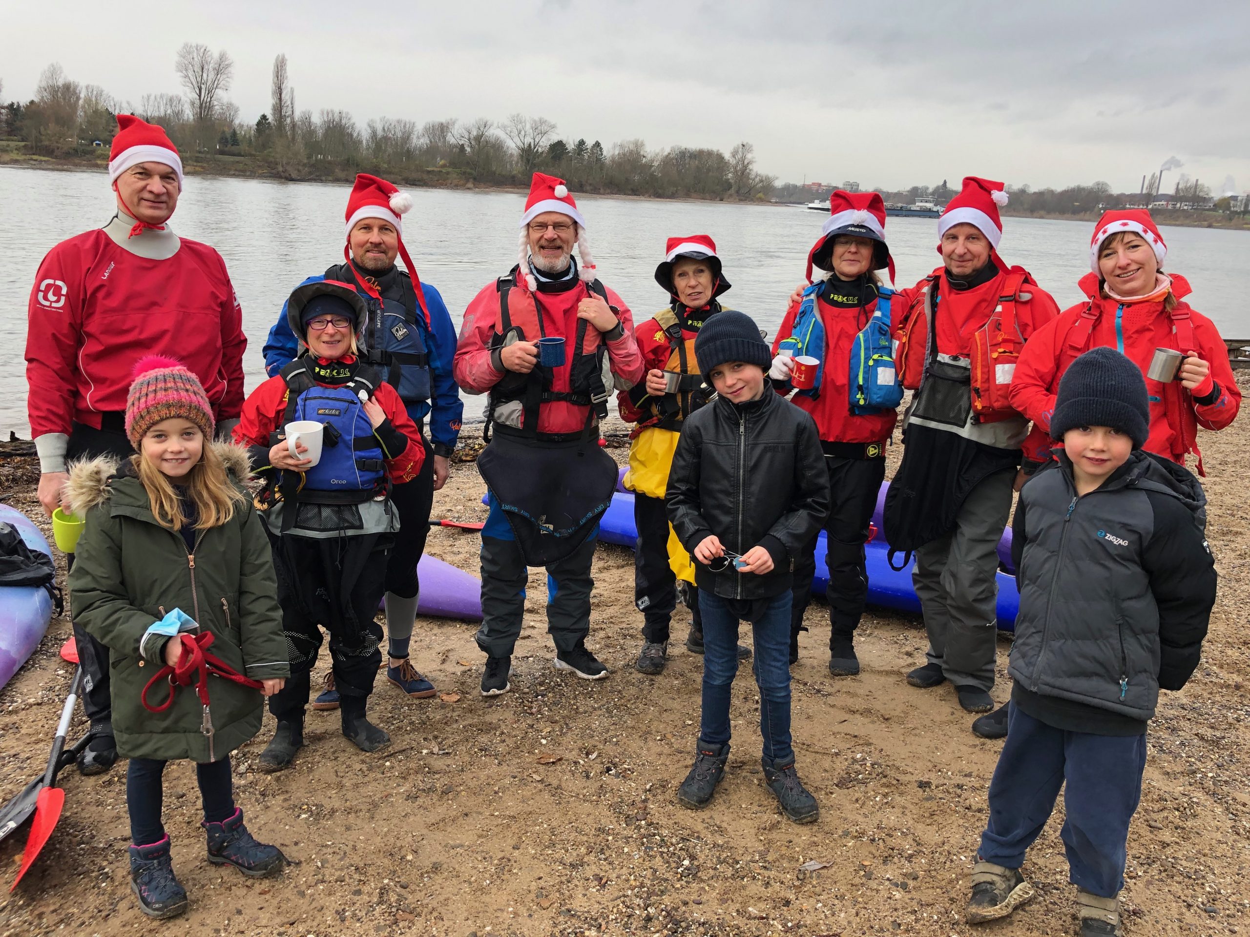 Gruppenfoto Kanufahrer mit Nikolausmützen am Rheinufer